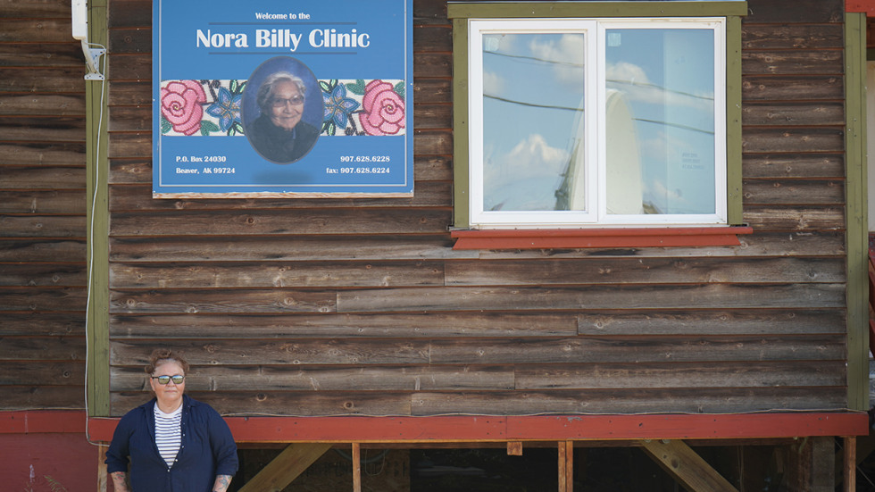 Woman poses in front of health clinic