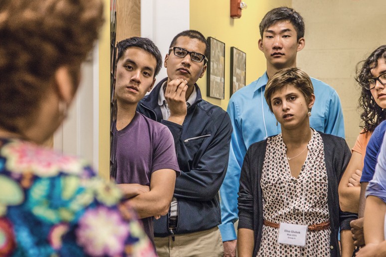 Medical students, including Faiz Khan ’15 MD ’19 (second from left), listen to a patient navigator at Clínica Esperanza. (Credit: Mike Cohea)