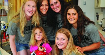 GOOD SPORTS: Members of the women’s volleyball team visit a patient at Hasbro Children’s Hospital last summer. Photo by Bill Murphy/Lifespan