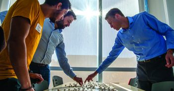 ASK AROUND: Adam Levine, right, shows Henry Sookram, left, and Khaled Almilaji how to randomly survey a refugee camp using a model made with sugar cubes and wooden stirrers. Photo by David DelPoio