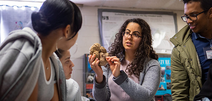 At Central Falls High School, Maya Ayoub MD'19 shows where the spinal cord connects to the brain. Photo by Nick Dentamaro